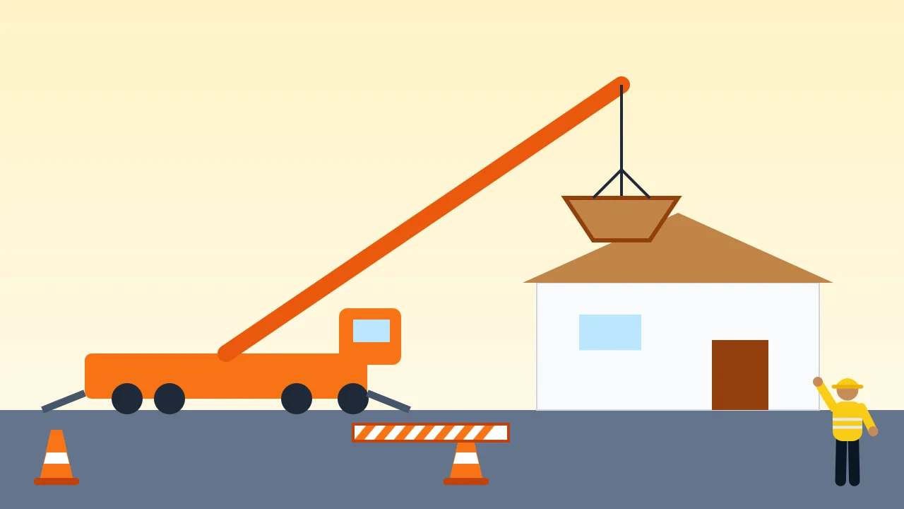 A mobile crane lifting roof trusses onto a house with the street coned off